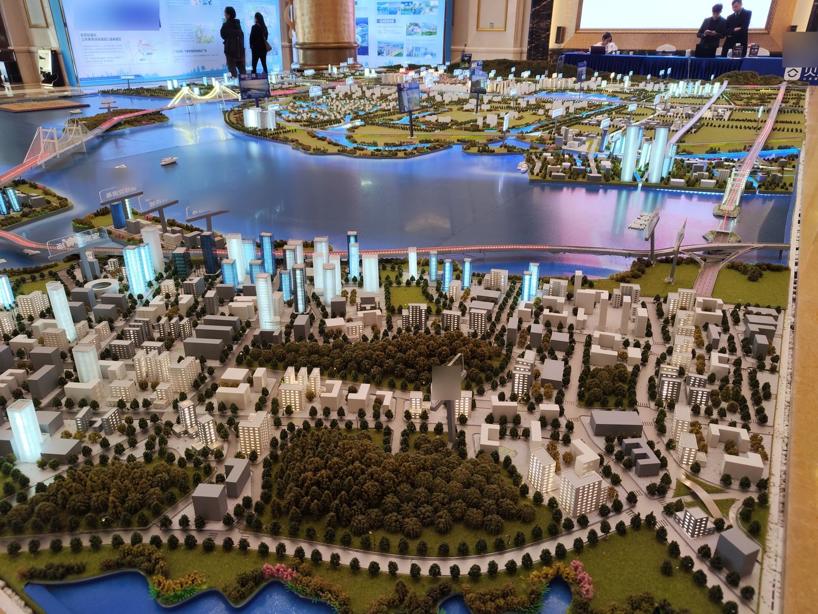 Aerial city plan scale model with waterway and lit districts