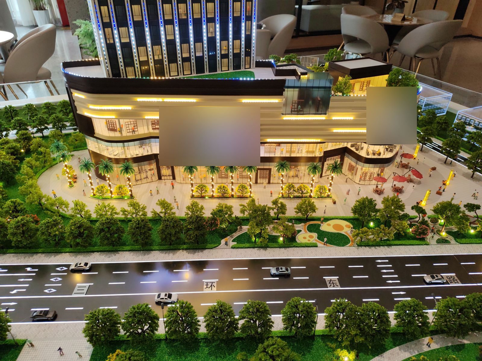 Street-front shopping mall model with illuminated facade strips and a landscaped forecourt