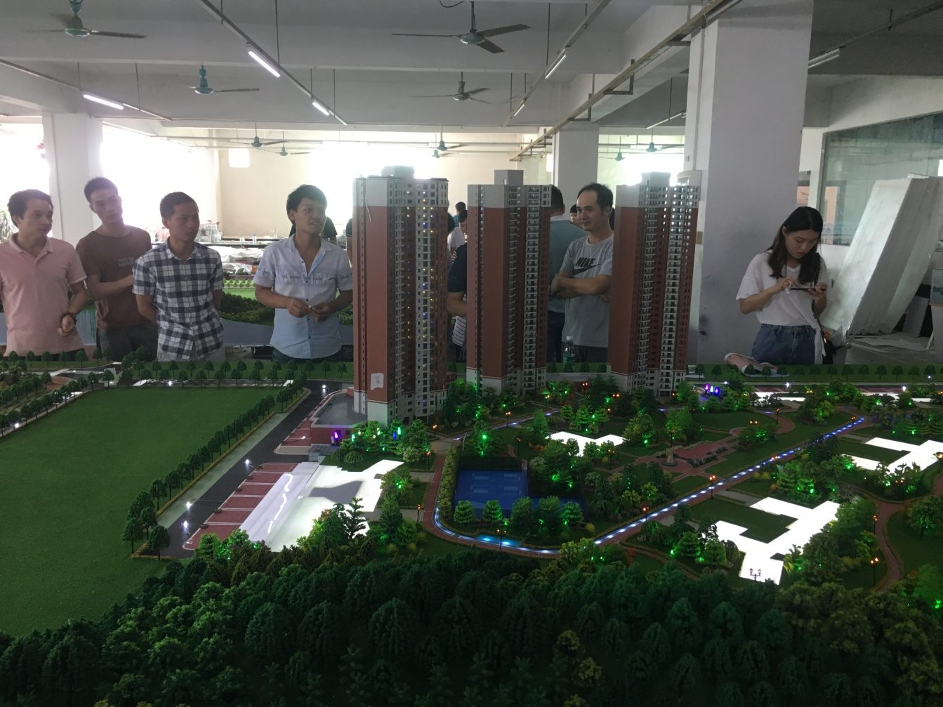 Team reviewing a housing-project model in the workshop