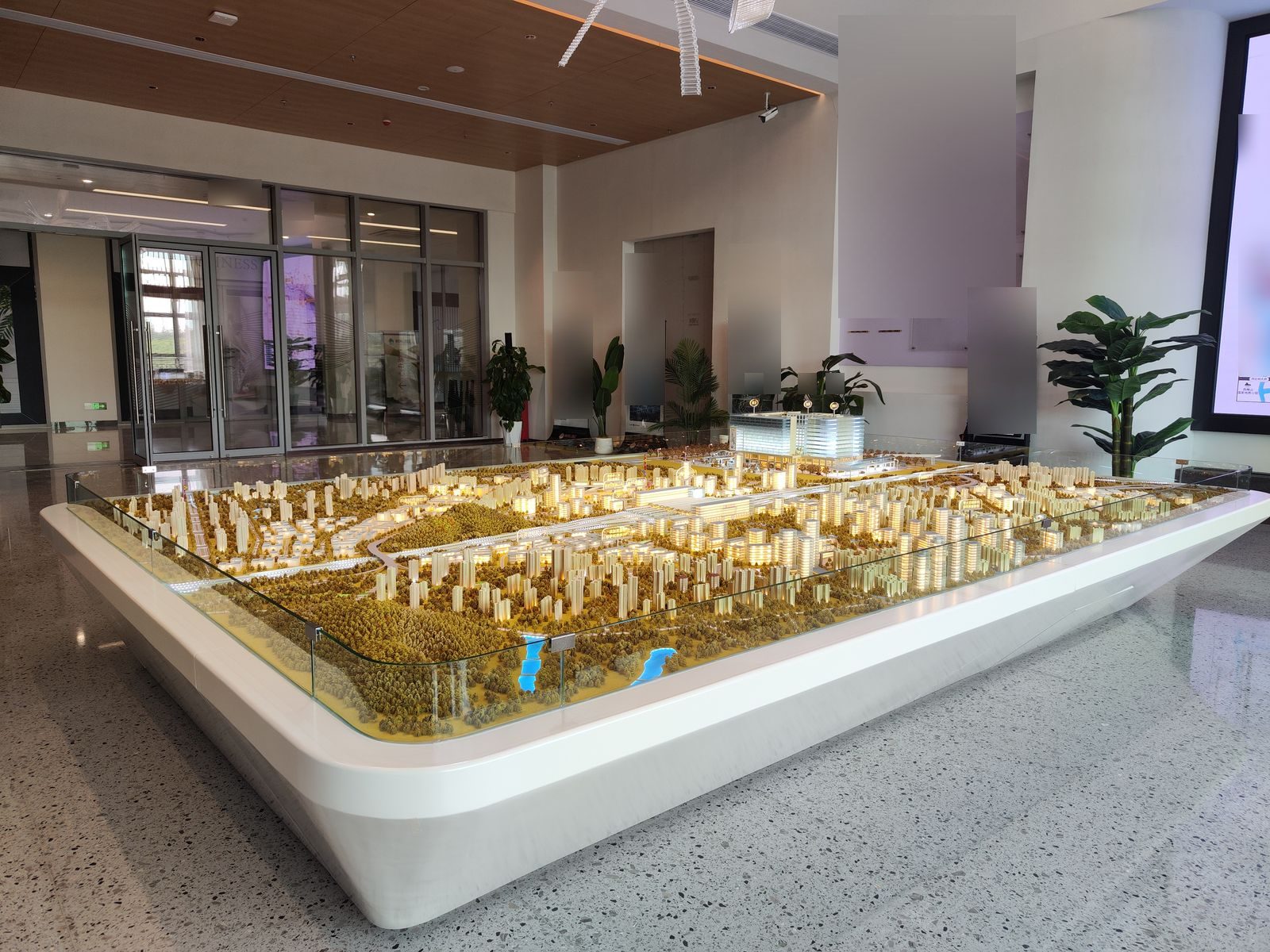 Illuminated city master-plan scale model displayed in a bright showroom