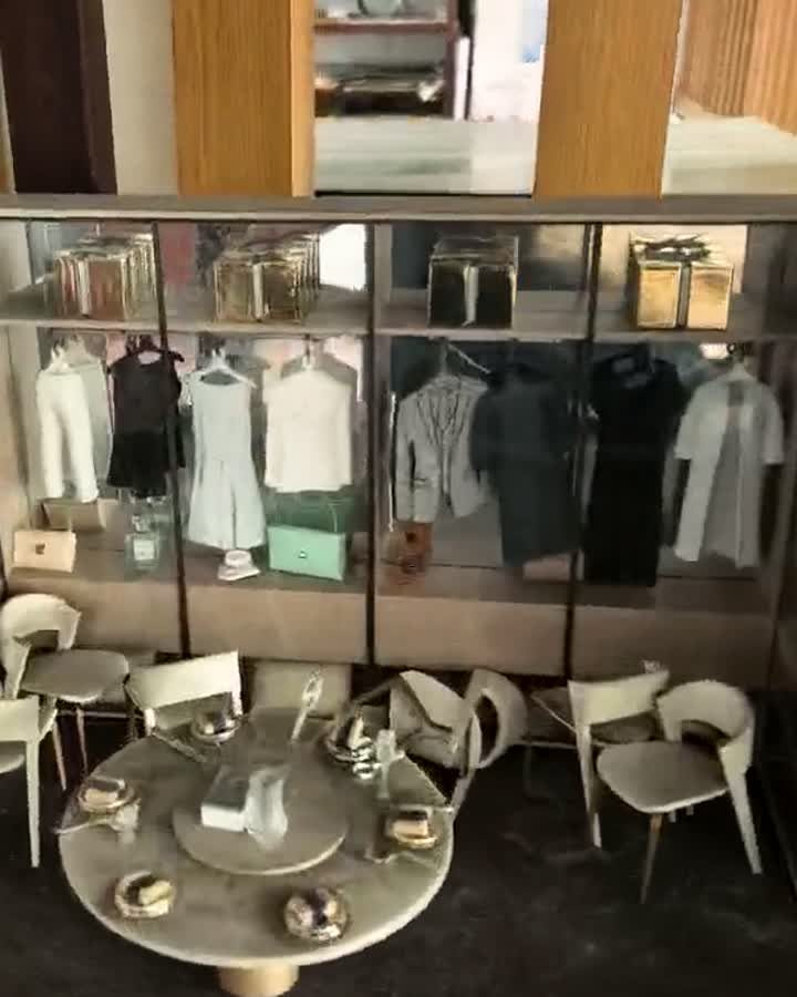 Interior cut-away detail of a furnished unit model with miniature figures, table and clothing rails